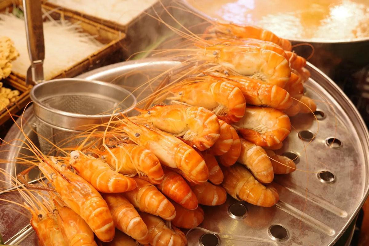 Freshly steamed shrimp stacked on a tray
