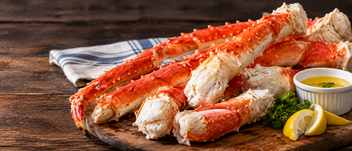 Alaskan king crab legs split to show the meat, with butter and lemon
