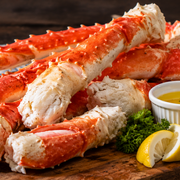 Alaskan king crab legs split to show the meat, with drawn butter