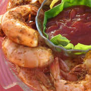 Steamed and seasoned jumbo Gulf shrimp with cocktail sauce, close-up