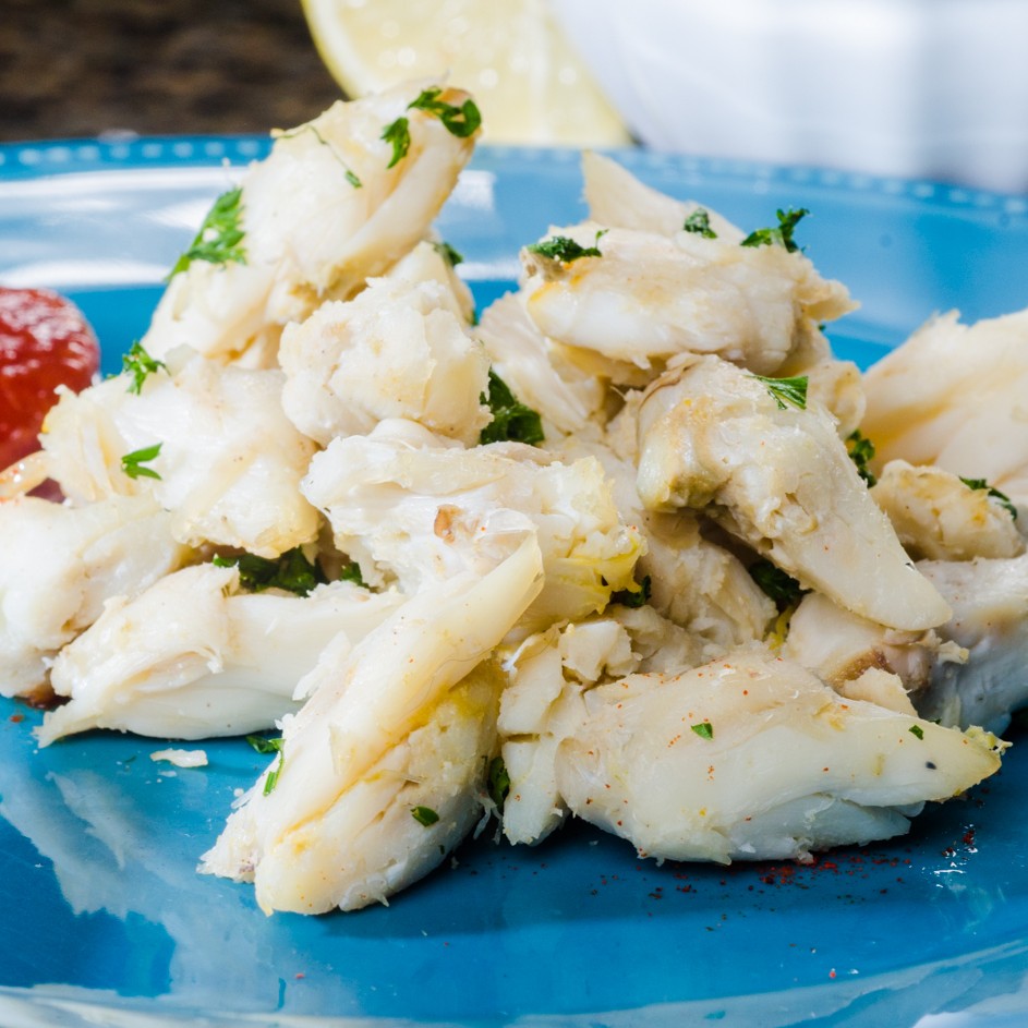 Jumbo lump crab meat plated, large white pieces with cocktail sauce
