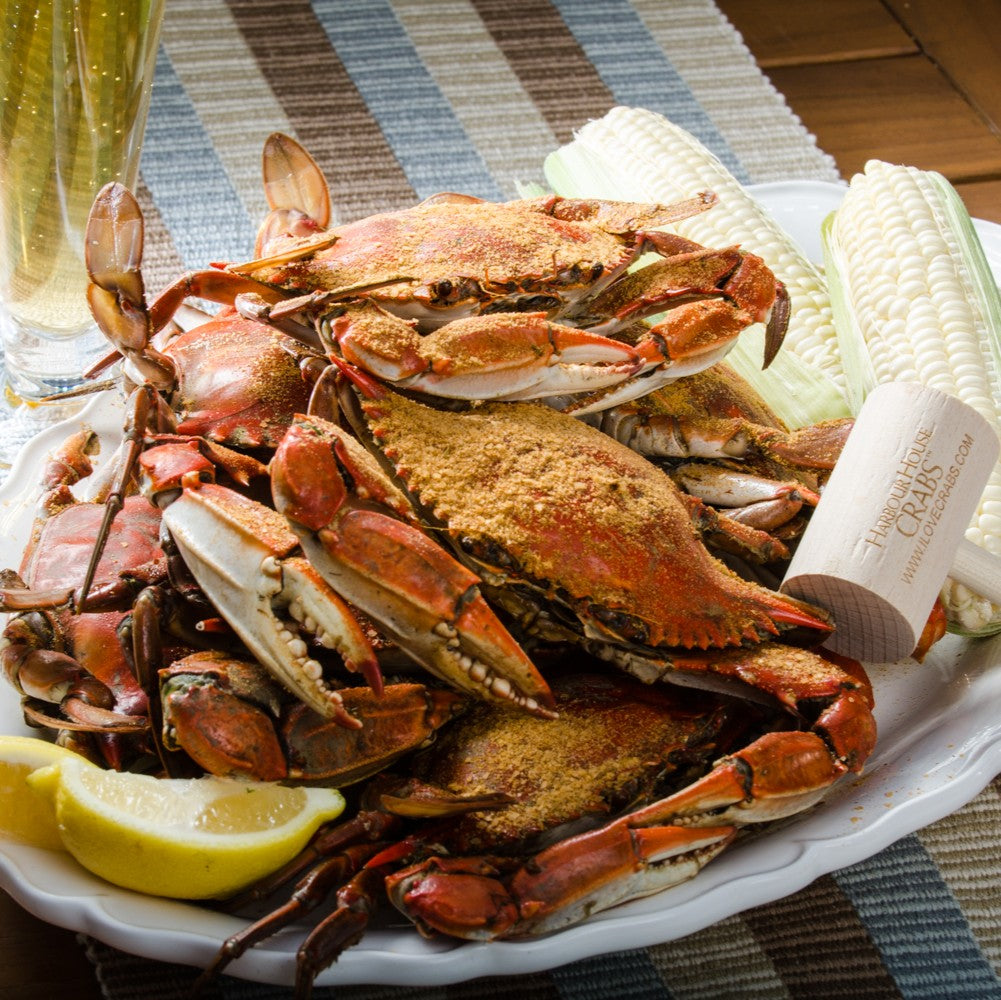 Steamed large male blue crabs on a platter with corn and lemon