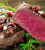 Grilled Angus beef tenderloin cut in half to show a pink center