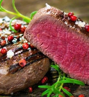 Grilled beef tenderloin filet halved to show a rosy center
