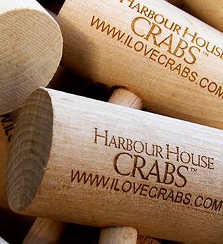 Wooden crab mallets engraved with Harbour House Crabs, close-up