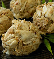 Jumbo lump crab cakes on a dark plate showing large crab lumps